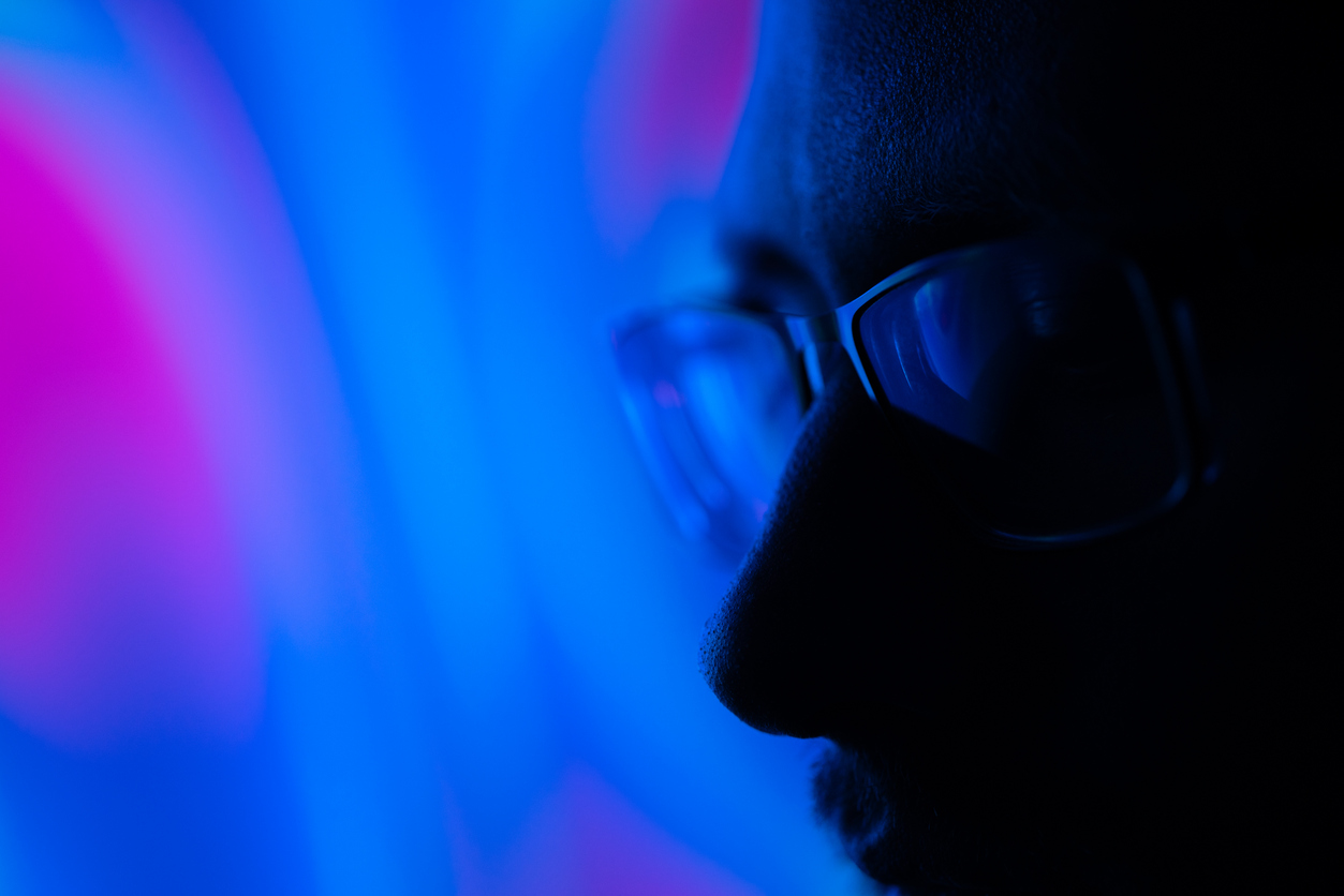 Cybersecurity professional in neon blue and pink light