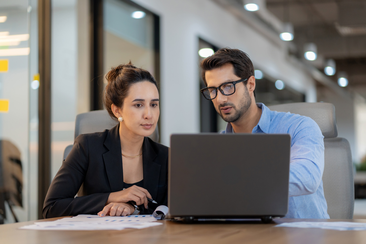 Cybersecurity mentor working with mentee at a laptop